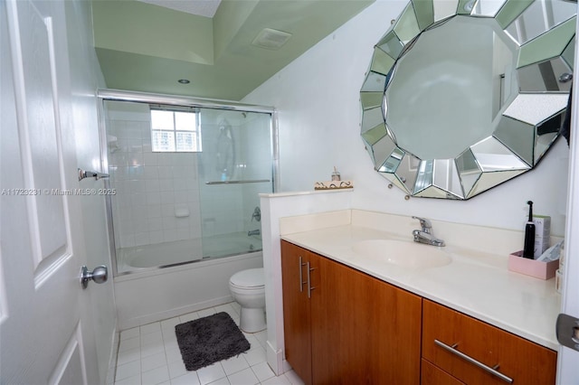 full bathroom with tile patterned flooring, bath / shower combo with glass door, vanity, and toilet