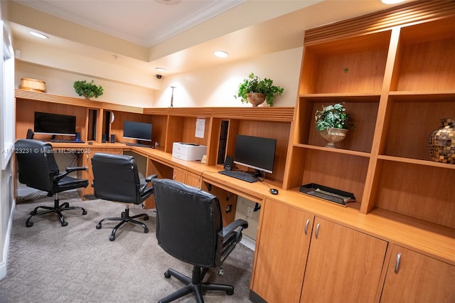 carpeted office space with crown molding and built in desk