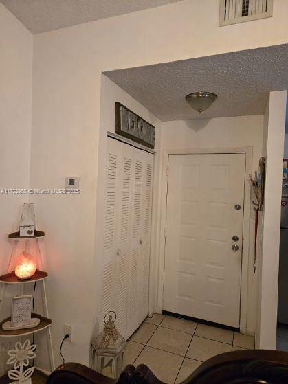 21340 NE 8th Ct Unit 1, Miami, FL 33179 - entryway featuring light tile patterned floors and a textured ceiling