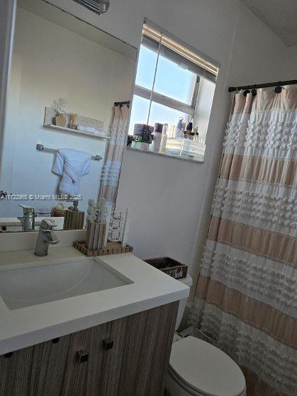 21340 NE 8th Ct Unit 1, Miami, FL 33179 - bathroom with vanity, toilet, and curtained shower