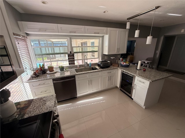 kitchen featuring white cabinetry, dishwasher, sink, hanging light fixtures, and kitchen peninsula