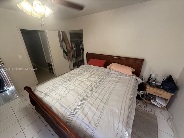 bedroom featuring tile patterned flooring, ceiling fan, a spacious closet, and a closet