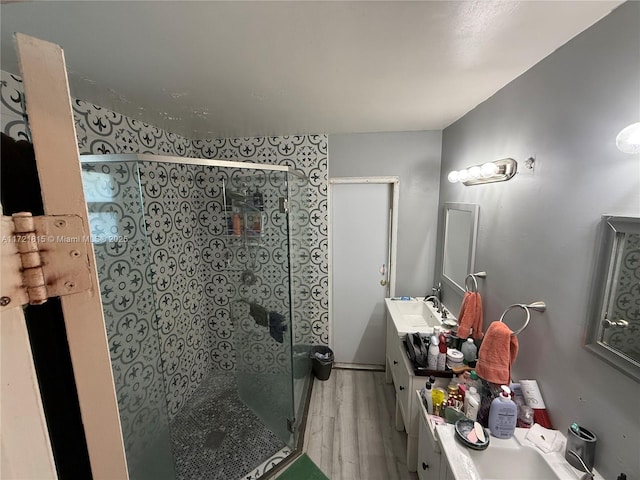 bathroom featuring wood-type flooring, vanity, and walk in shower