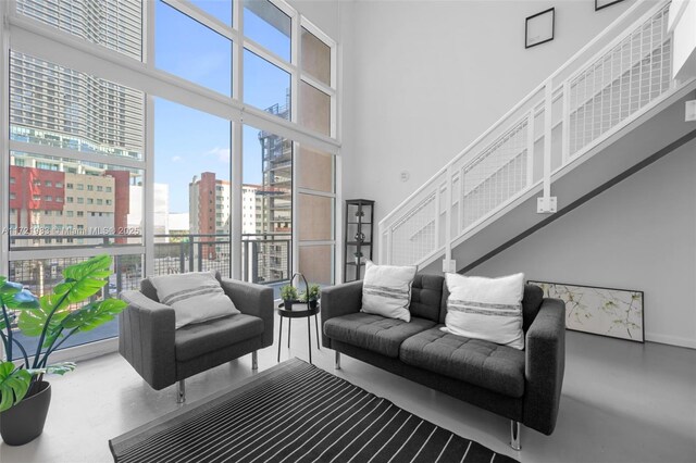 living room with concrete flooring and a high ceiling