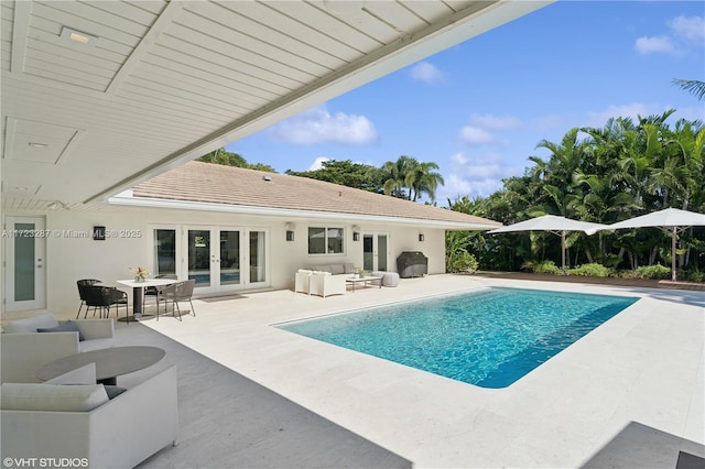 view of swimming pool featuring grilling area, an outdoor living space, french doors, and a patio