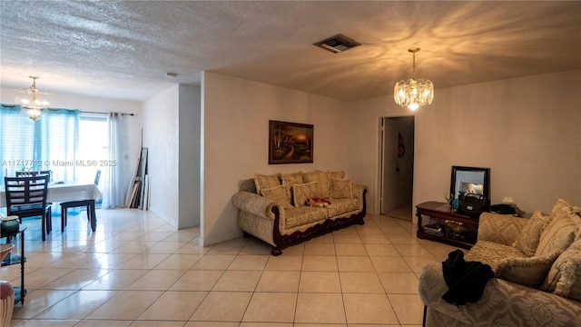 tiled living room featuring a textured ceiling and a notable chandelier