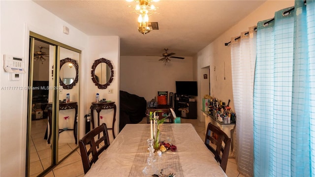 tiled dining area with ceiling fan and a textured ceiling