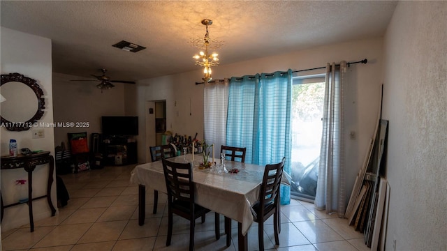 dining space with ceiling fan with notable chandelier, light tile patterned floors, and a textured ceiling