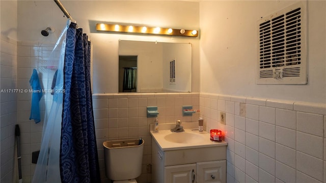 bathroom featuring toilet, vanity, tile walls, and walk in shower