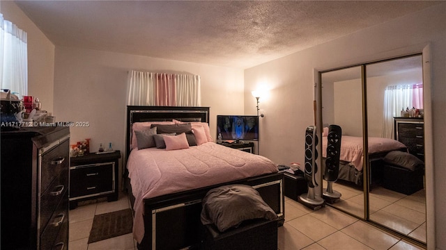 tiled bedroom with a closet and a textured ceiling