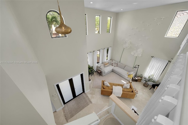 living room with light tile patterned floors and a high ceiling