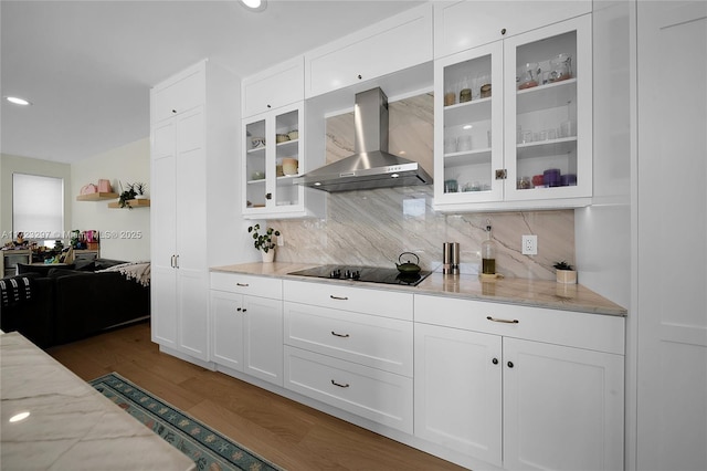 kitchen with white cabinets, wall chimney exhaust hood, dark hardwood / wood-style floors, light stone counters, and black electric cooktop