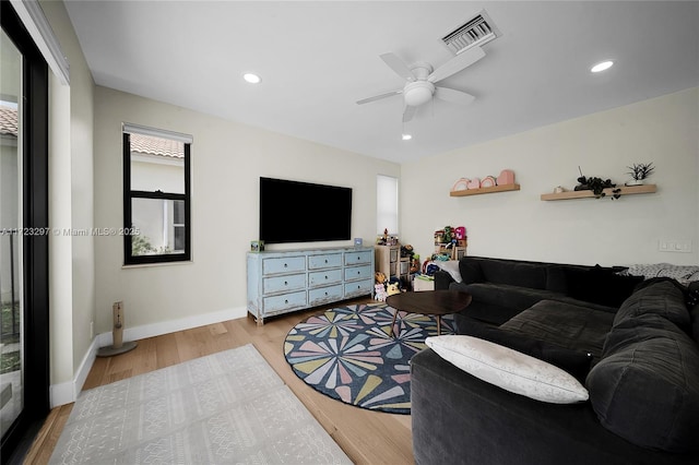 living room with ceiling fan and light wood-type flooring