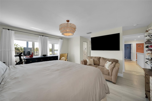 bedroom featuring light hardwood / wood-style floors and a chandelier