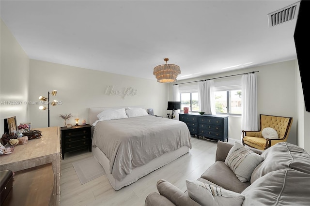 bedroom with light wood-type flooring and a chandelier