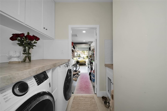 laundry area featuring washing machine and dryer and cabinets