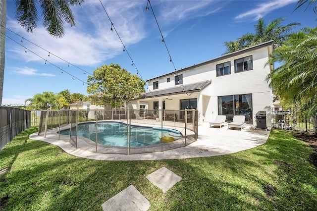 view of swimming pool with grilling area, a patio area, and a lawn