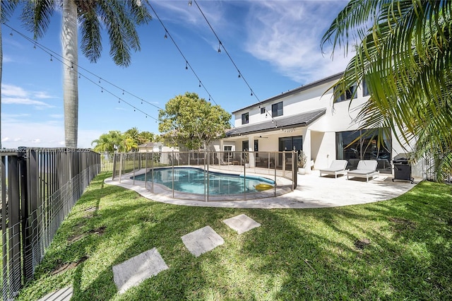 view of pool with a patio and a yard