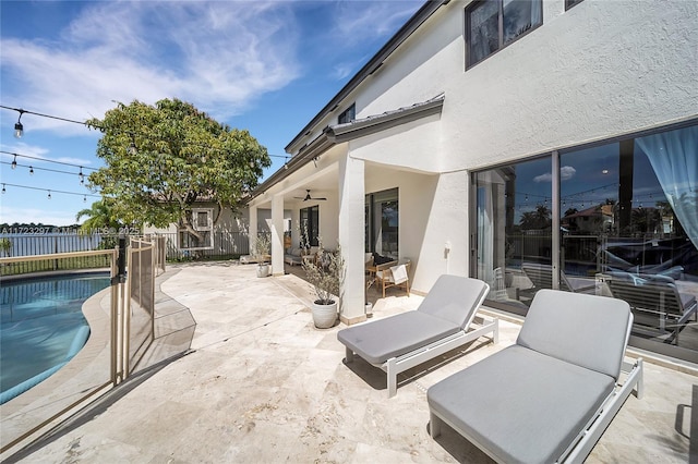 view of patio with ceiling fan and a fenced in pool