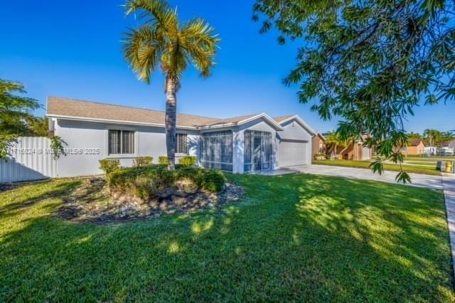 single story home with a sunroom, a garage, and a front yard