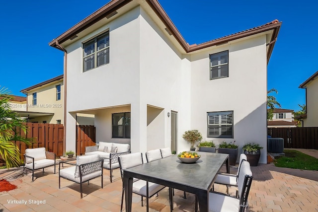 rear view of property with outdoor lounge area and a patio