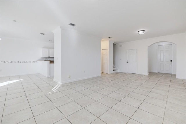 tiled spare room featuring crown molding