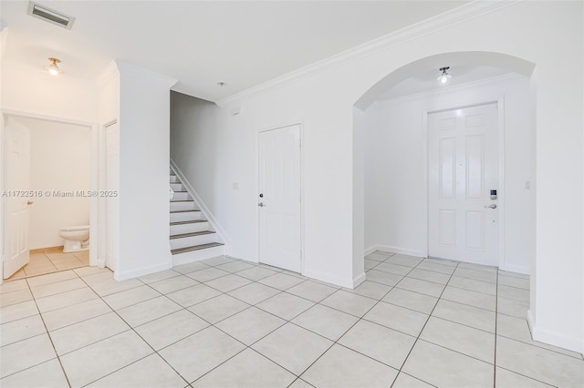 foyer featuring crown molding and light tile patterned floors