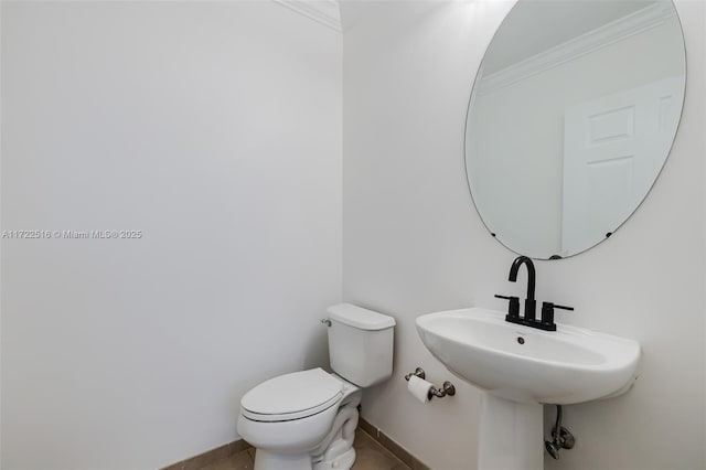 bathroom featuring toilet and crown molding