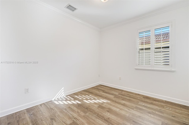 spare room featuring crown molding and light hardwood / wood-style floors