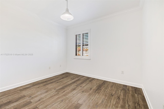 empty room with dark hardwood / wood-style floors and crown molding