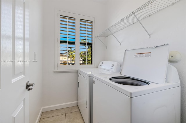 washroom with light tile patterned floors and washing machine and dryer