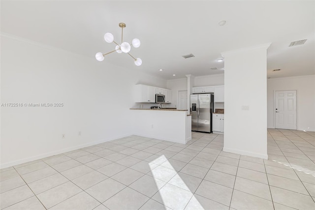 kitchen featuring kitchen peninsula, crown molding, appliances with stainless steel finishes, white cabinetry, and light tile patterned floors