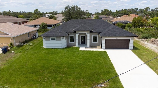 view of front of home featuring concrete driveway, a garage, a front yard, and a shingled roof