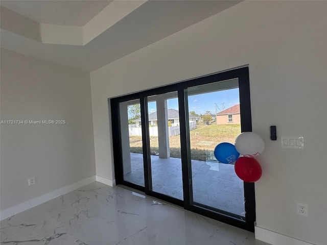 doorway to outside with marble finish floor and baseboards