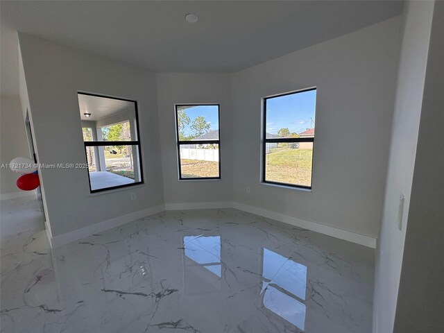 empty room with marble finish floors and baseboards