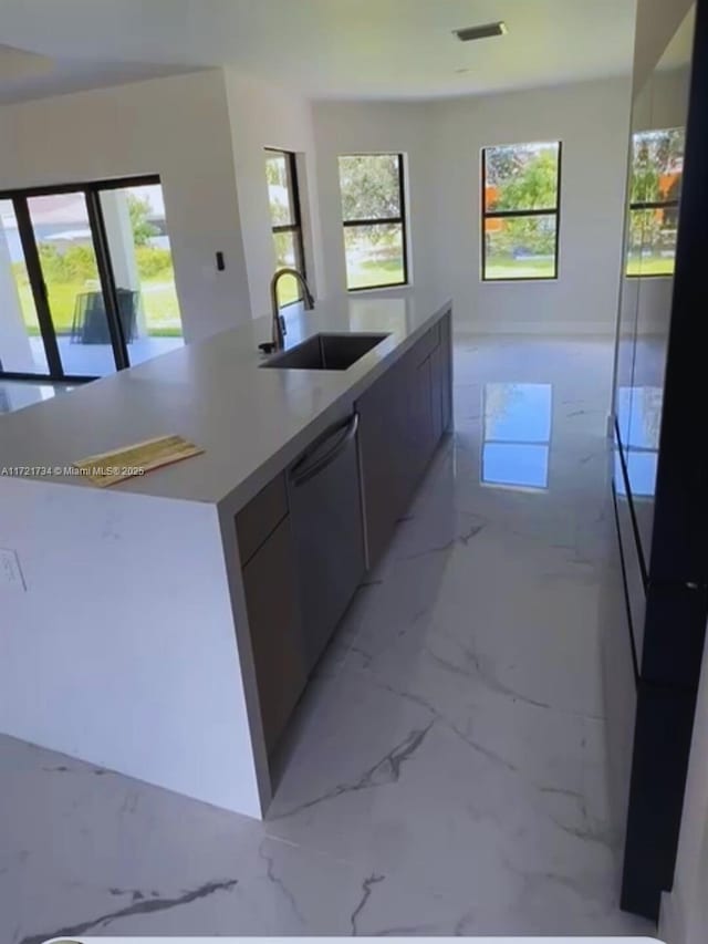 kitchen featuring a center island with sink, dishwasher, and sink