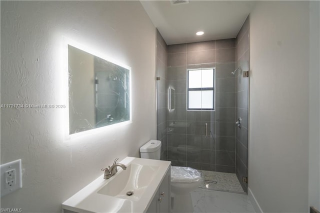 bathroom featuring a shower with shower door, vanity, and toilet