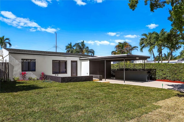 rear view of property featuring a lawn