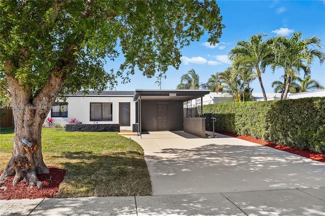 view of front of house with a front yard and a carport