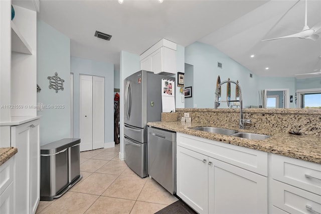 kitchen with light stone countertops, stainless steel dishwasher, ceiling fan, sink, and white cabinetry