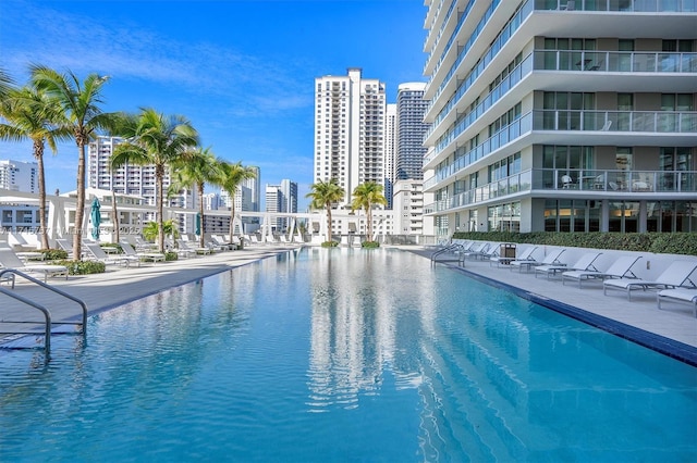 view of swimming pool featuring a water view and a patio