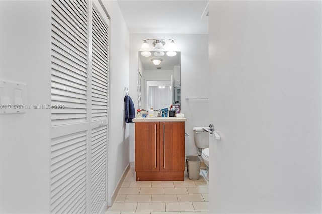 bathroom with toilet, tile patterned flooring, and vanity