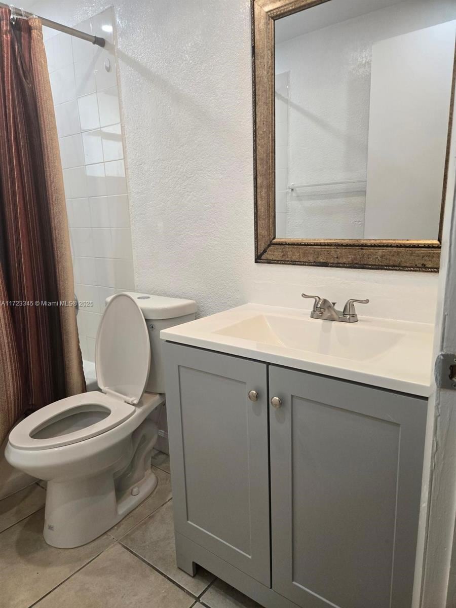 bathroom featuring tile patterned flooring, vanity, and toilet