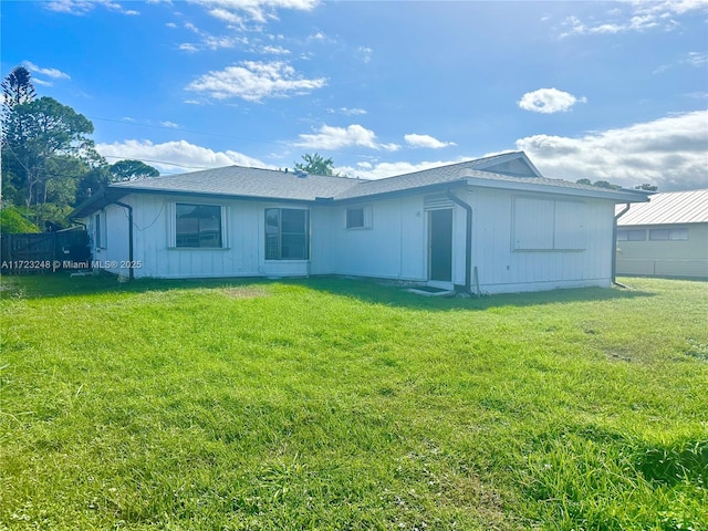 back of property featuring a lawn