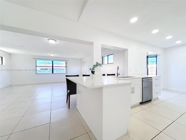 kitchen with white cabinetry, a center island, sink, and light tile patterned floors