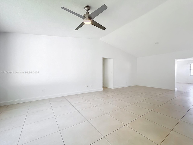 spare room featuring vaulted ceiling, ceiling fan, and light tile patterned flooring