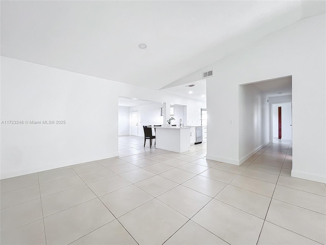 unfurnished living room with vaulted ceiling and light tile patterned floors