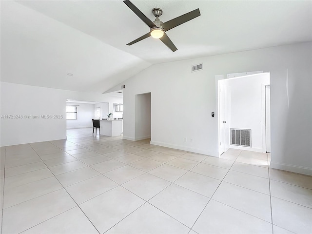 unfurnished room with vaulted ceiling, ceiling fan, and light tile patterned flooring