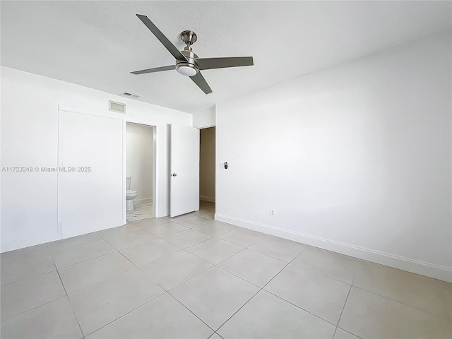 spare room with light tile patterned floors, a textured ceiling, and ceiling fan