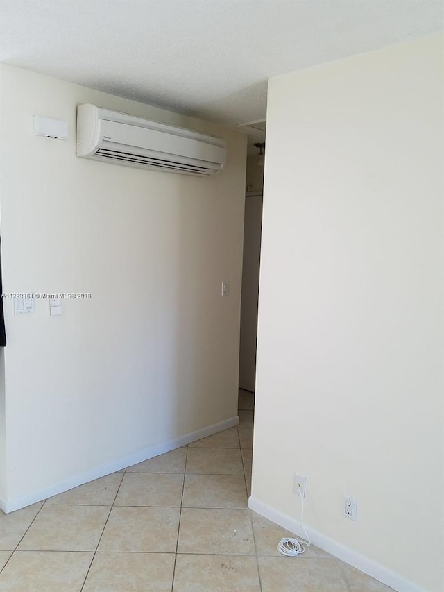 tiled spare room with an AC wall unit